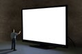 Man pointing tv remote control at worldÃ¢â¬â¢s biggest giant television with blank screen